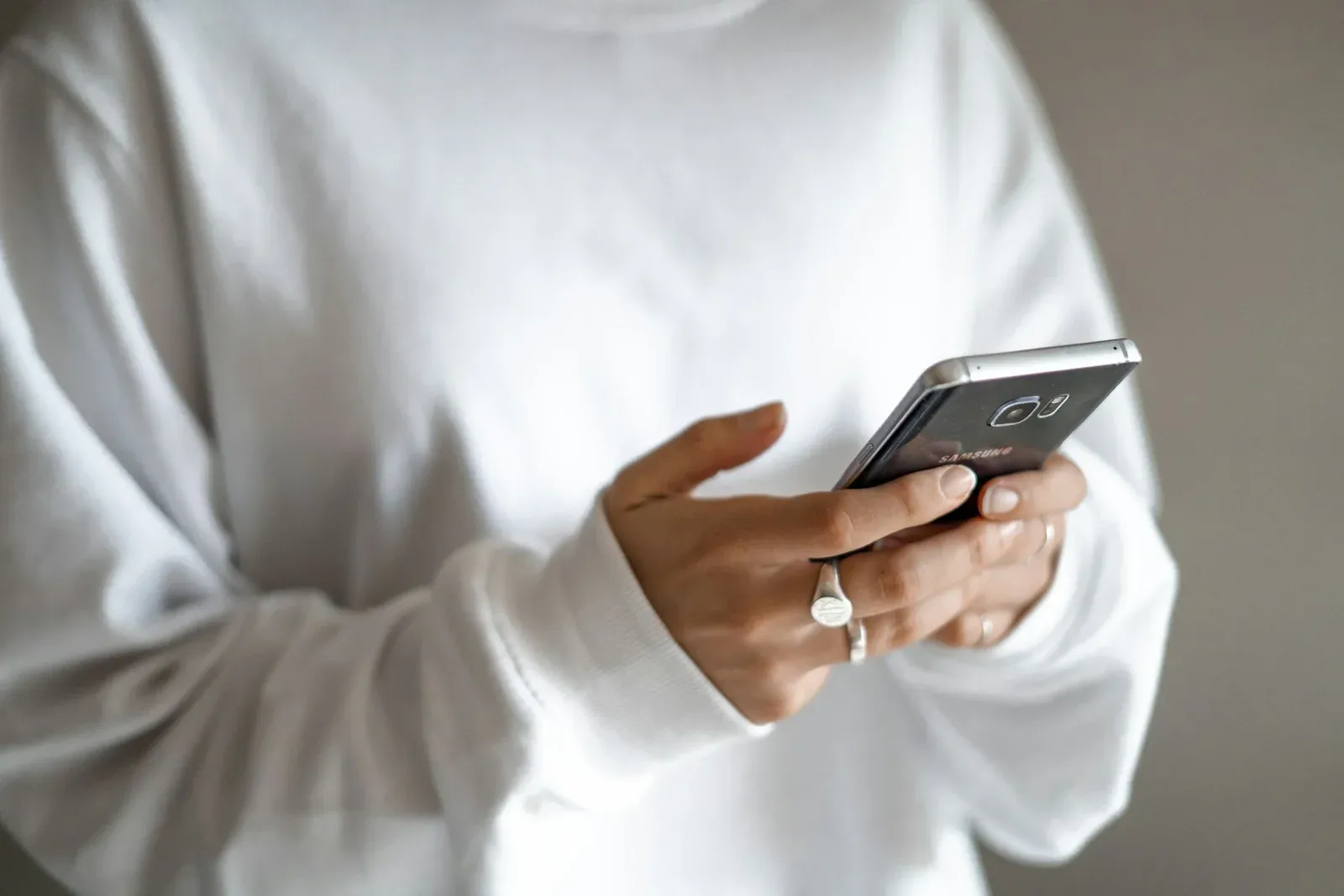 A person casually holding a phone, about to check it